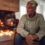 Mature man sitting by fire place in living room