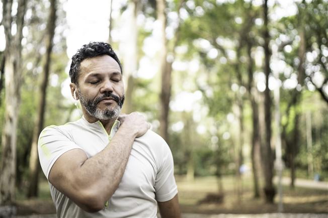 Middleaged man grasping shoulder in pain during workout