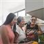 Three generations of women in the kitchen cooking and laughing