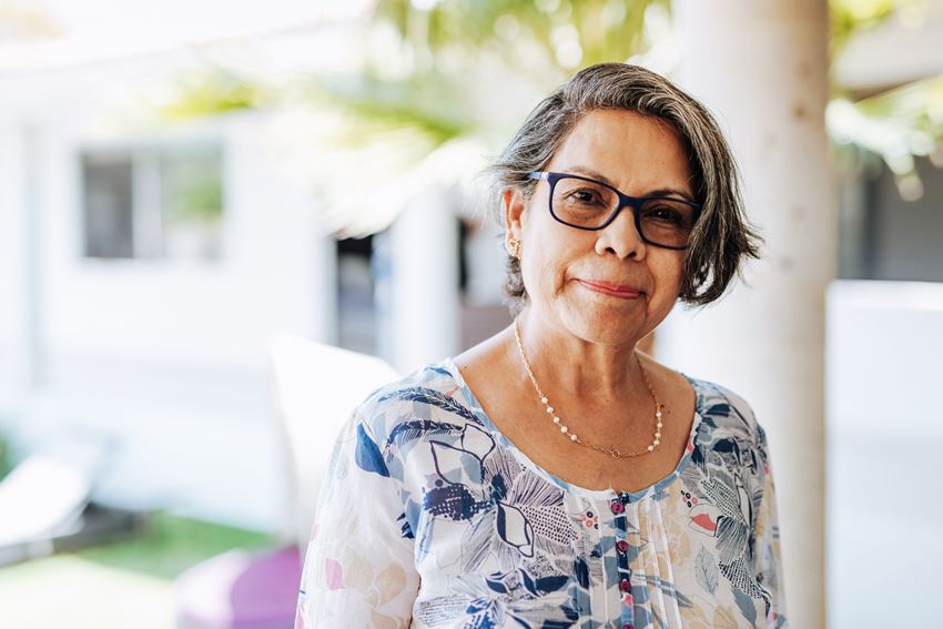 Senior Hispanic woman with glasses smiling at camera