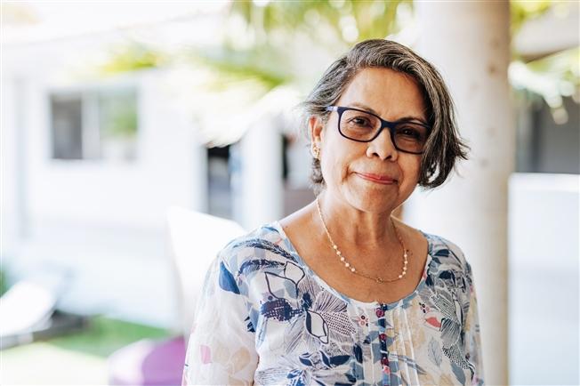 Senior Hispanic woman with glasses smiling at camera