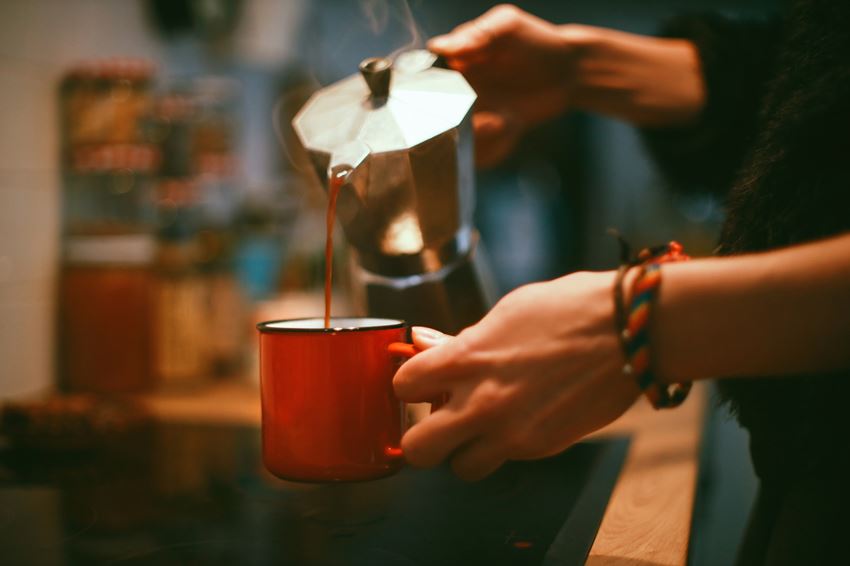 Closeup of a womans hands pouring coffee