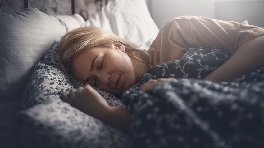 Young woman falling asleep in bed at night