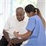 Senior Black man in doctors office reviewing medical information with health care provider