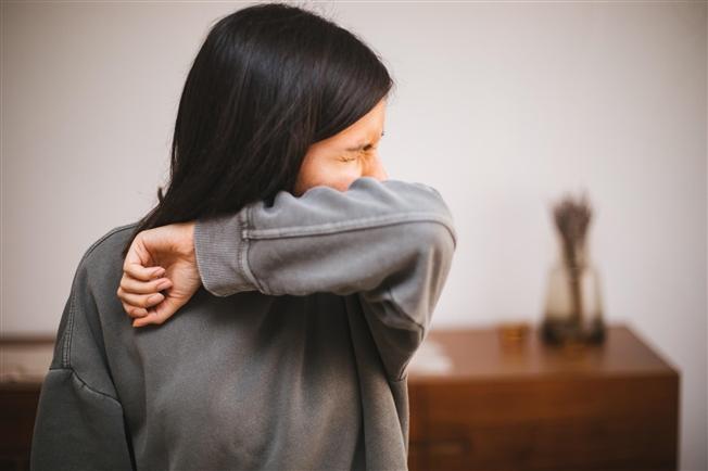 Allergies and acupuncture Woman sneezing into arm during allergy season