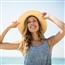 Smiling woman standing against background of sky
