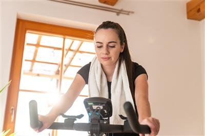 Young woman on spin bike at home