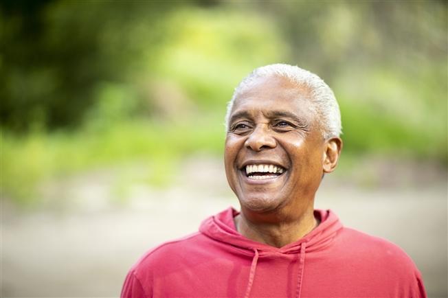 Senior man smiling and hiking in woods