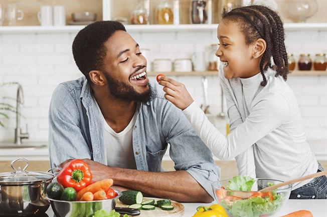 Child feeding dad healthy food