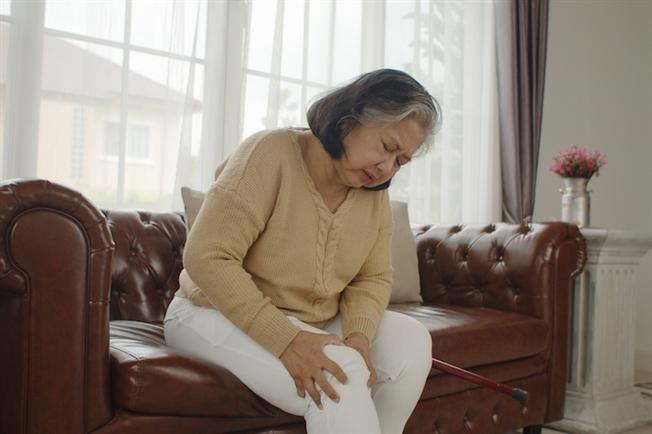 woman holding leg in pain