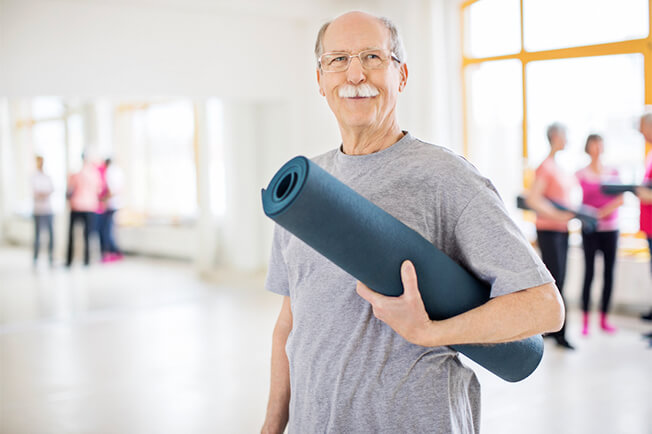 Older man with yoga mat