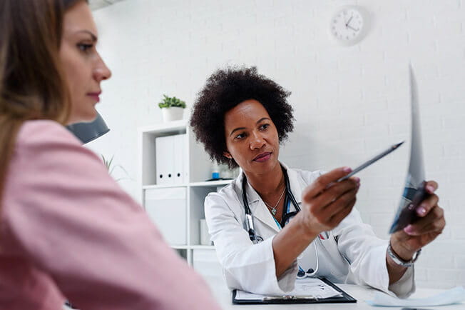 Female physician showing woman results of breast exam