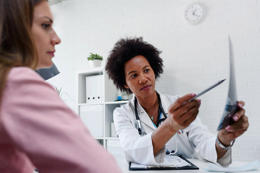 Female physician showing woman results of breast exam