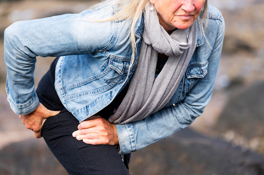 woman taking break from walk, holding hip