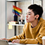 Person working at desk with pride flag in the background