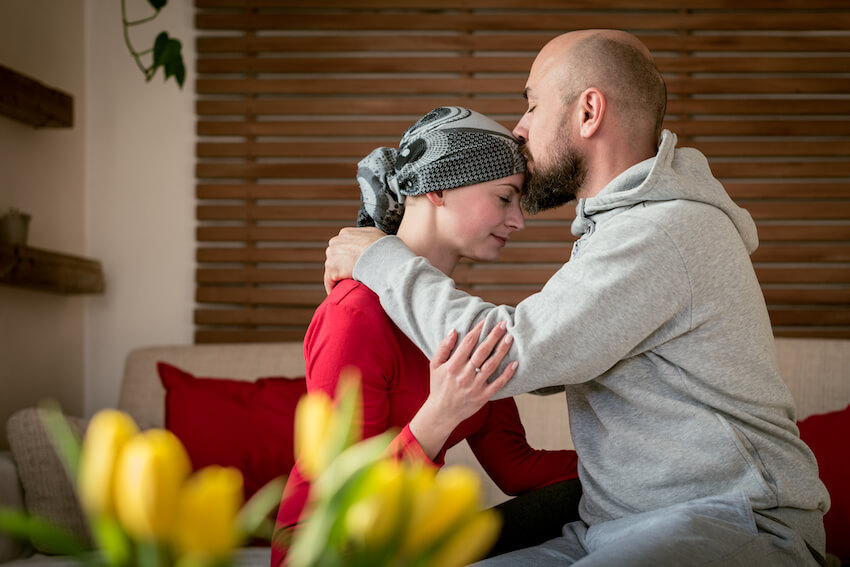 man kissing wife recovering from cancer treatment