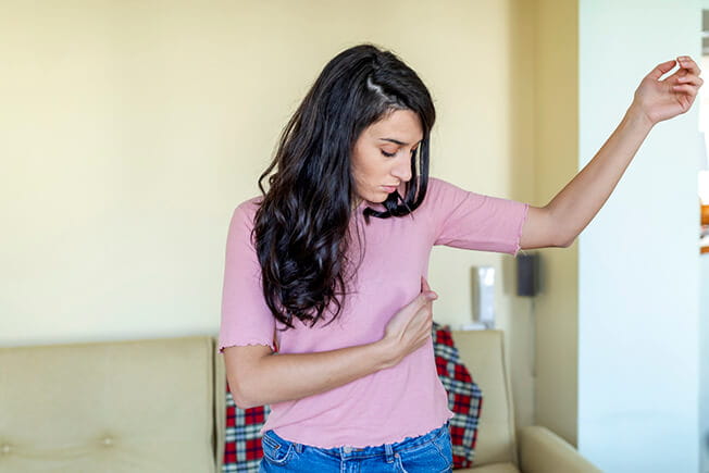 Woman examining side of breast