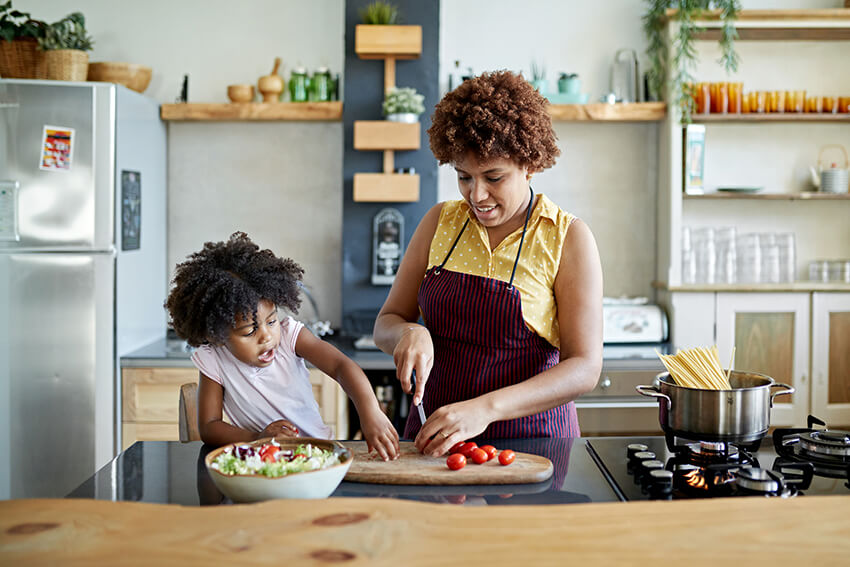 woman making healthy meal with young daughter