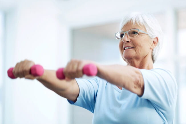 older adult woman using free weights