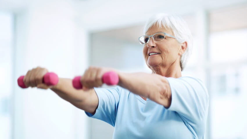 older adult woman using free weights
