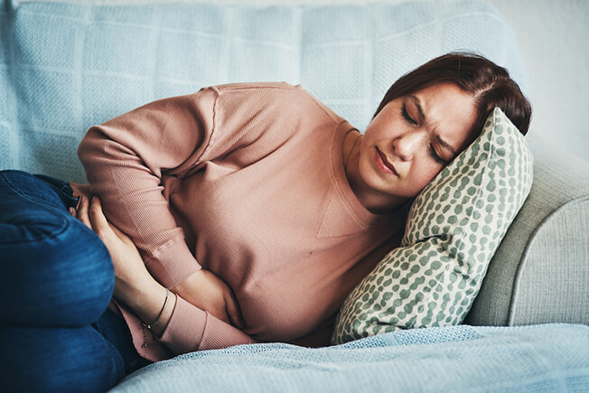 woman holding abdomen in pain