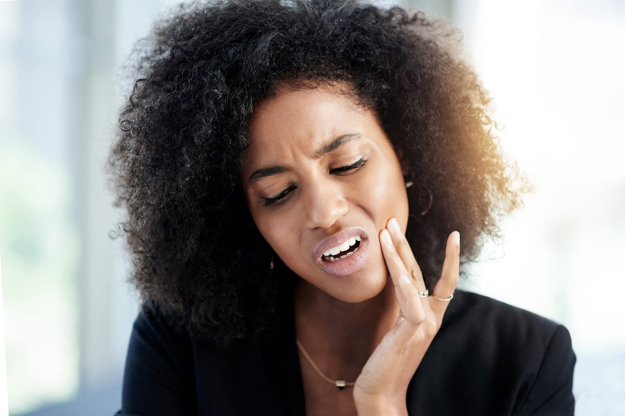 woman holding head in pain