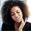 woman holding head in pain