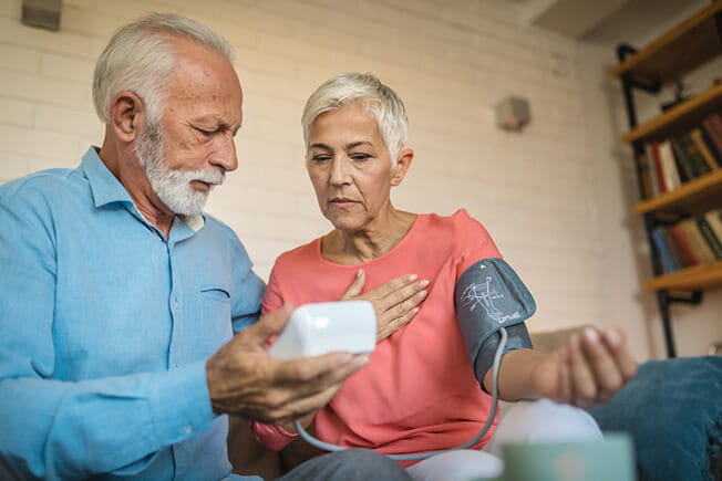 Senior couple using device to measure blood pressure