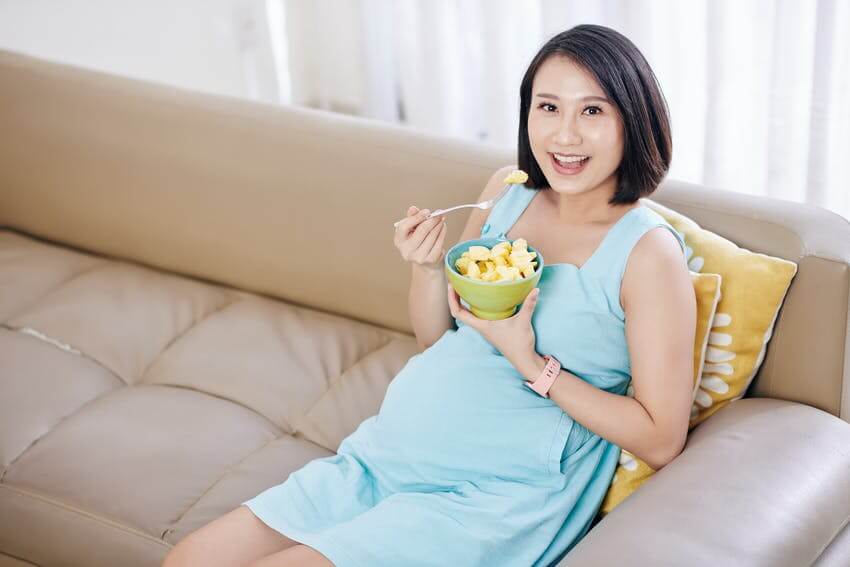 Pregnant woman eating pineapple