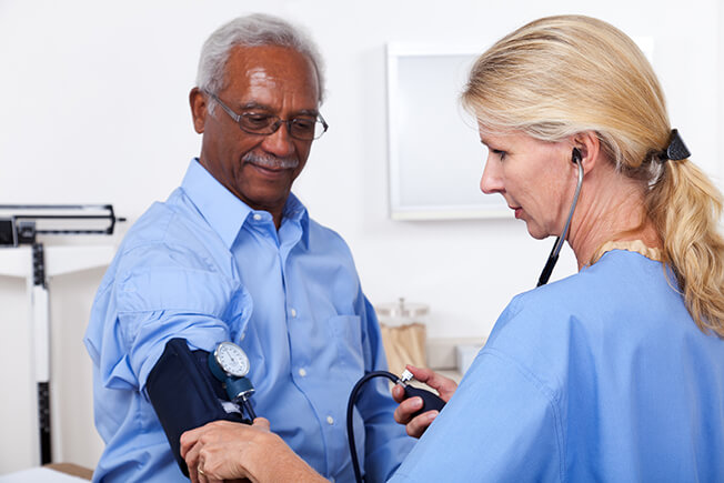 Clinician taking man's blood pressure