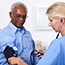 Clinician taking man's blood pressure