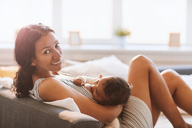 young woman breastfeeding baby baby at home