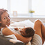 young woman breastfeeding baby baby at home