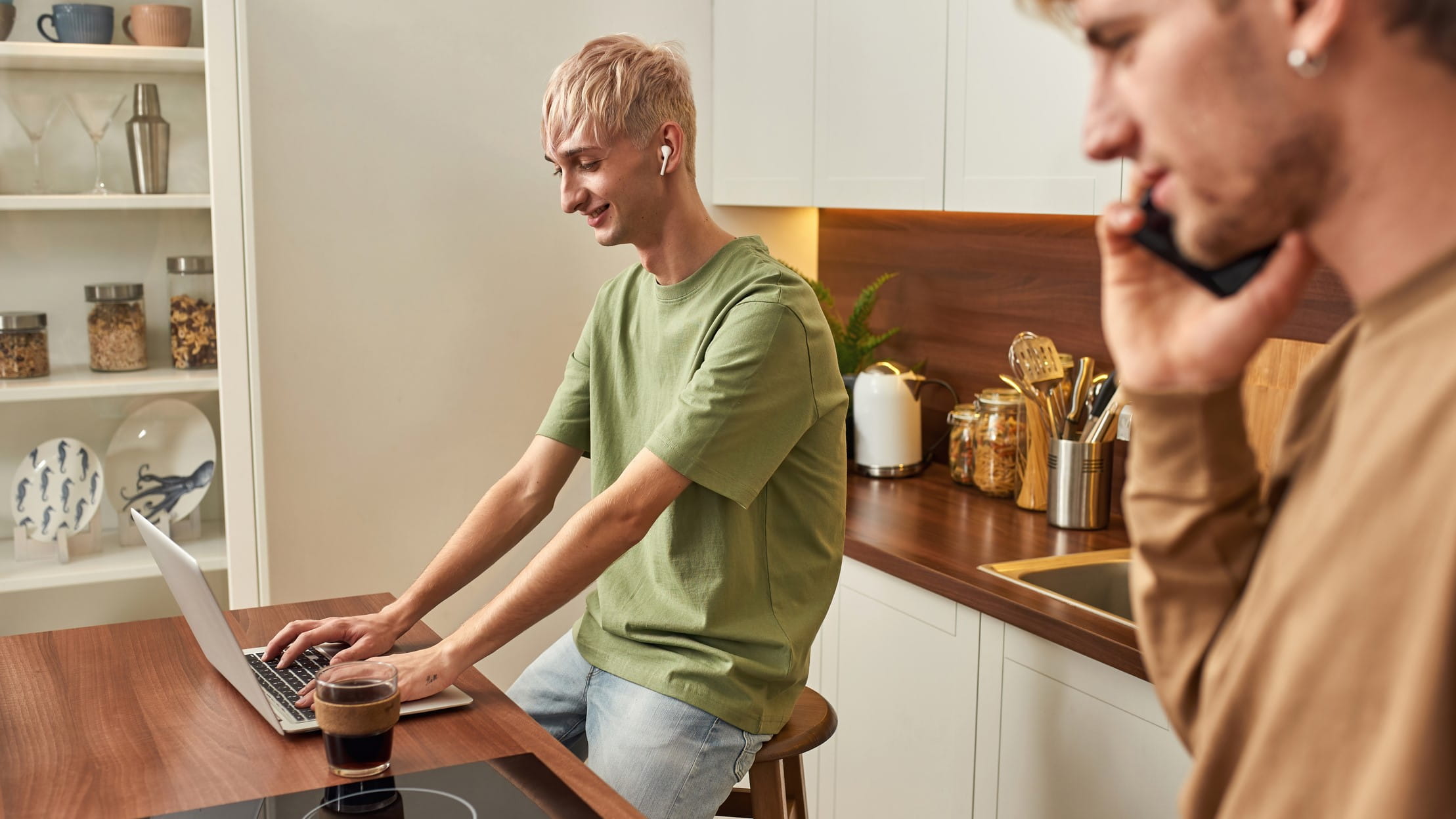 Happy caucasian male couple working in modern kitchen