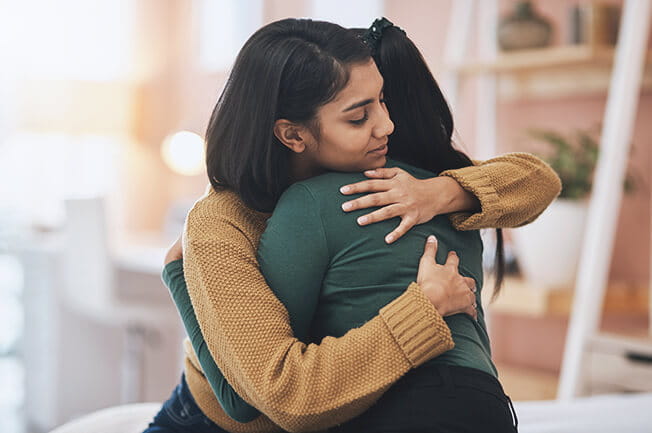 Two woman embracing each other