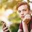 unhappy teenage boy with smartphone