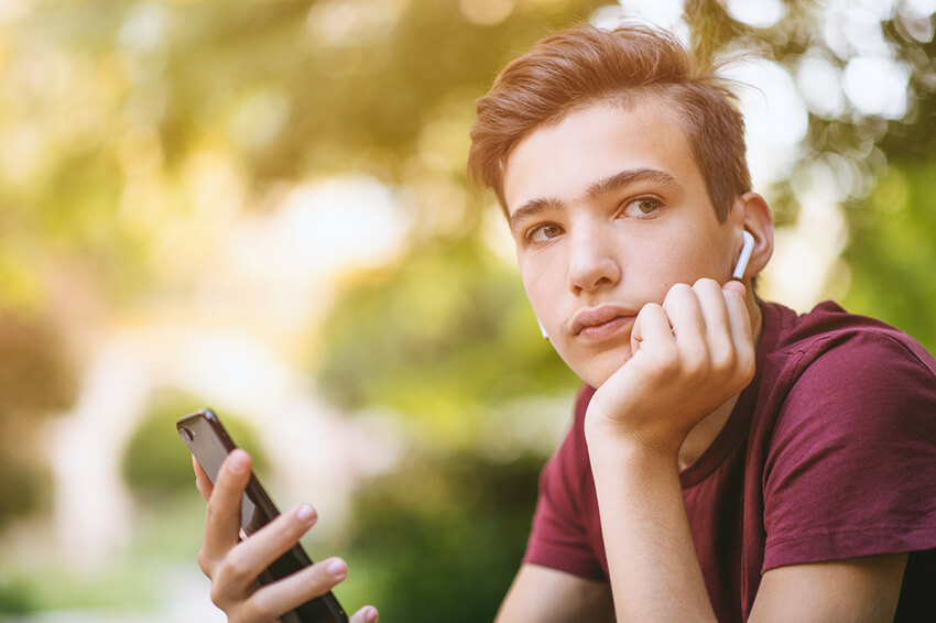 unhappy teenage boy with smartphone