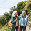 Two older women laughing together while they hike.