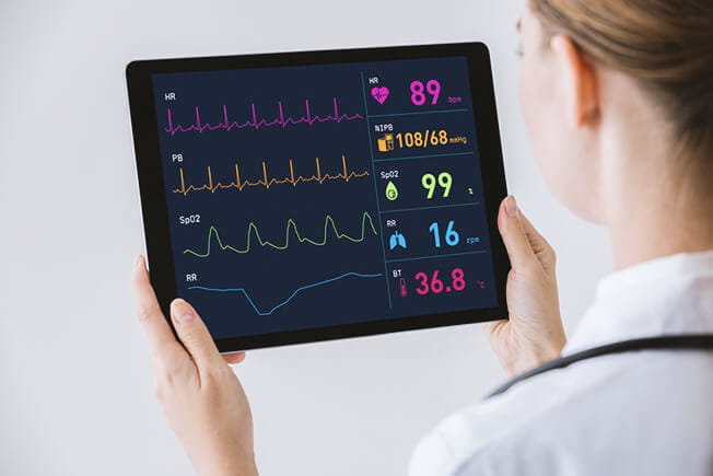 Doctor watching vital signs with tablet