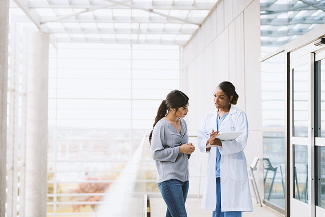 Doctor explains patient's test results to woman.