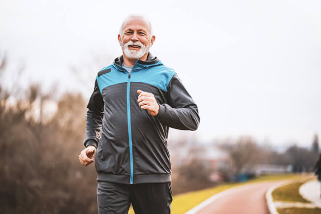 Senior man running outdoors.