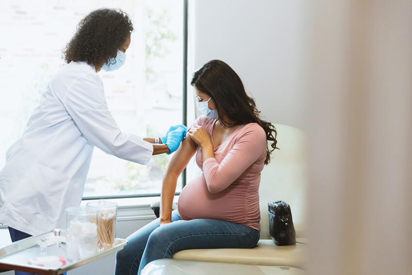 Pregnant woman receives vaccine at doctor's office