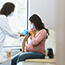 Pregnant woman receives vaccine at doctor's office