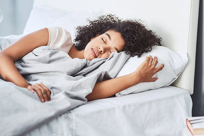 Young woman sleeping in bed