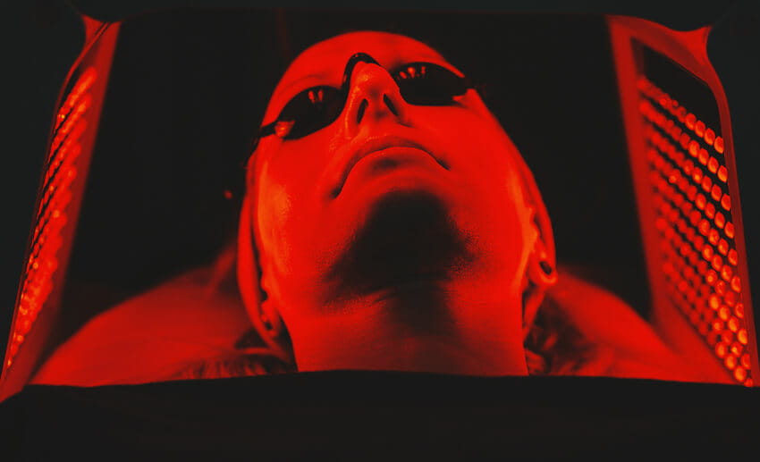 Young woman having red light therapy treatment.