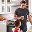 Two children in a kitchen with an adult.