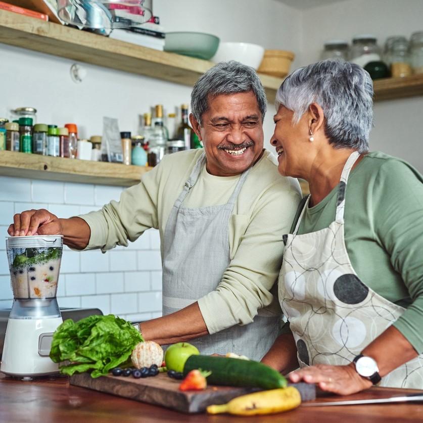 Senior couple preparing a healthy smoothie in the kitchen at home.