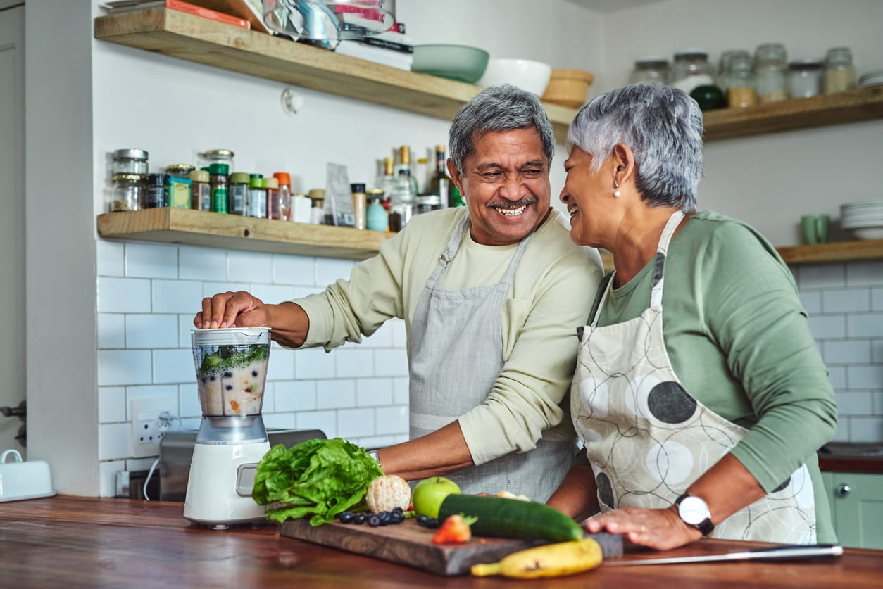 Senior couple preparing a healthy smoothie in the kitchen at home.