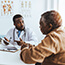 Male doctor speaking with an older male patient.