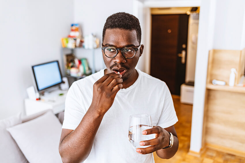 Man taking an aspirin at home.